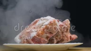 一块冷冻猪肉肚或牛肉肉旋转，慢吞吞地在烟雾中停留