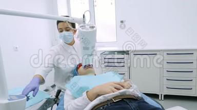 女士在牙科医生办公室用紫外线`机器进行紫外线<strong>美</strong>白.