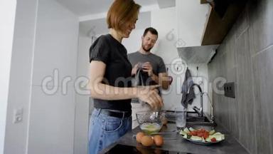 快乐的<strong>配偶</strong>们周末早上在厨房做早餐，女人做煎蛋卷，男人洗餐具