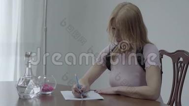 一位身材苗条、金发碧眼、身穿矫形胸衣的漂亮女人坐在桌子上写着一封信