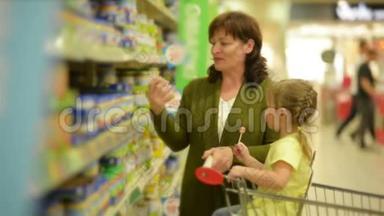 祖母和<strong>孙女</strong>正在购物中心购买物品。 <strong>孙女</strong>坐在购物手推车里。