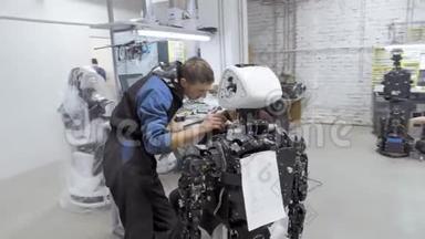 生产机器人的工厂。 两名工程师<strong>正在</strong>检查一个机器人。 在实验室里创造一个新的机器人。 <strong>修理</strong>