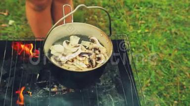 一个女人`手把蘑菇放在火上的水壶里<strong>煮汤</strong>。