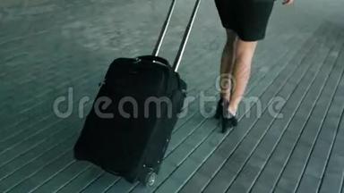 穿着黑色高跟鞋、带旅行行李走路的瘦女人腿
