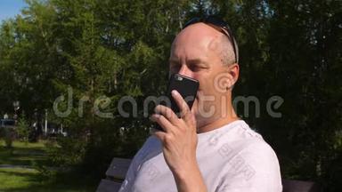 在城市公园里，一个英俊的男人打着手机看着镜头
