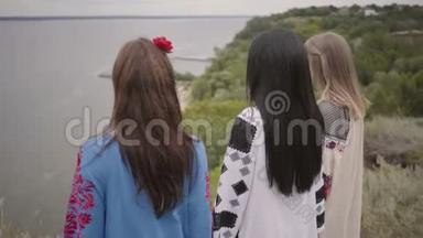 三个可爱的女朋友穿着夏天的长时装，在湖边或湖边散步