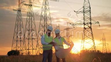 电力线路工人在日落背景下与施工计划一起工作。