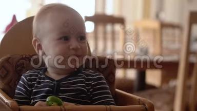 小宝宝坐在婴儿椅上吃食物。