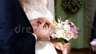 婚礼传统，仪式。 结婚典礼。 新婚夫妇在无名指上戴着彼此的戒指。 特写镜头。