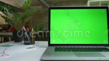 带有绿色屏幕特写的电脑在白色的桌子上，办公<strong>环境</strong>、工作心情、空间<strong>空旷</strong>