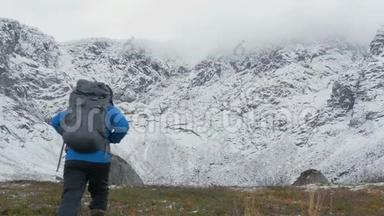 一个带背包的人在山里旅行。 他望着高高的山峰，走得更远。 他的身体健康