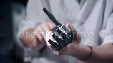 一位科学家工程师正在测试一种电子仿生假肢。 他用<strong>机械手臂</strong>的塑料手指