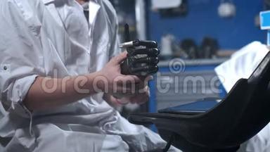 一位科学家工程师正在测试一种电子仿生假肢。 他用机械手臂的塑料手指