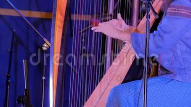 无法辨认的女子在民族露天音乐会舞台上演奏竖琴