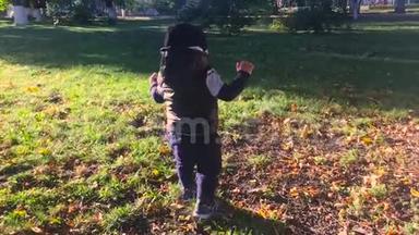 一岁的可爱男孩正在公园里迈出第一步。 孩子在户外迈出第一步。 慢动作录像。