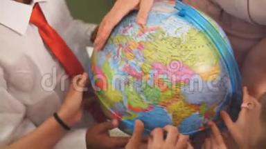 小学生和老师一起看地球仪上的地理课