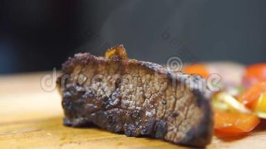 热烤牛肉BBQ牛排，条纹，蔬菜沙拉和酱汁在切板特写。