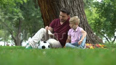 爸爸和儿子一起在公园看书，一起准备作业，做父母