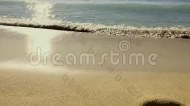 海景沙滩上有金色的沙滩，还有海浪缓缓拍打着海岸。阳光明媚的一天。