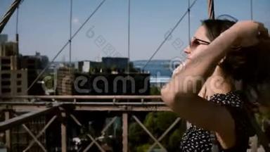 镜头跟随美丽快乐的欧洲女孩戴着老<strong>式</strong>太阳镜，金色的头发走在布鲁克林<strong>大桥</strong>4K。
