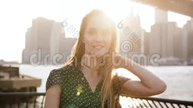 慢动作特写照片快乐的欧洲女孩走向镜头微笑布鲁克林大桥河景。