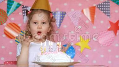 一个小女孩吹灭生日蛋糕上的蜡烛，用手指吃。 宝贝许愿