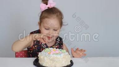 生日快乐。 一个可<strong>爱</strong>的女孩微笑，高兴，鼓掌，吃蛋糕，舔她的手指。