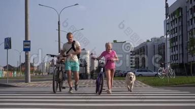 在现代城市与宠物生活-一个有自行车的家庭和一只大狗过<strong>马路</strong>