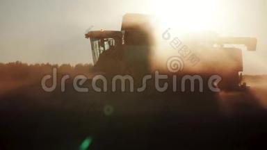 日落时在田里收割小麦的组合剪影