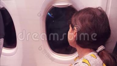 <strong>航空飞机</strong>概念。 年轻的少女在飞行时看着飞机在夜间的窗口飞行。 年轻乘客