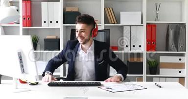 有耳机的商人在现代办公室工作。