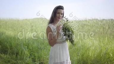 肖像可爱的年轻女孩，黑发，穿着一件白色的<strong>夏季</strong>时尚<strong>长裙</strong>，站在田野上。 休闲