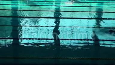 在泳池里，蓝水和泳道的<strong>分割</strong>让人无法辨认的游泳者轮廓