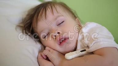 儿童体温在医院病房用体温计测量.. 特写镜头。 婴儿睡在医院病房的白色床上。