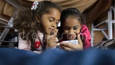 微笑学龄前女孩浏览智能手机网络