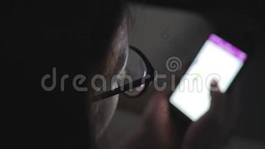 一位戴眼镜的女士坐在沙发上，用智能手机进行网上购物。 网上营销