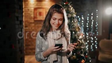 一个手里拿着火花的漂亮女孩正笑着，看着圣诞节手机上的照片