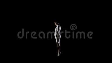 穿着白色衣服、黑色背景的英俊男体<strong>操</strong>运动员，在蹦床上缓慢地<strong>跳</strong>跃，表演翻转和<strong>跳</strong>跃