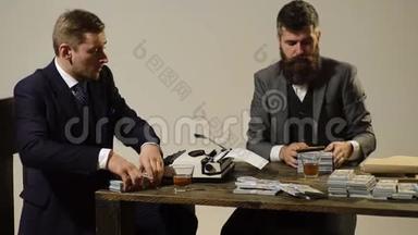 两个人坐在桌旁抽雪茄时算利润. 商人分利润。