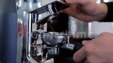 咖啡师用咖啡研磨机和支架研磨咖啡豆。 双手特写..