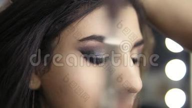 专业化妆师用特殊的画笔将眼影<strong>运用</strong>到模特`眼睛上。 美容、化妆和
