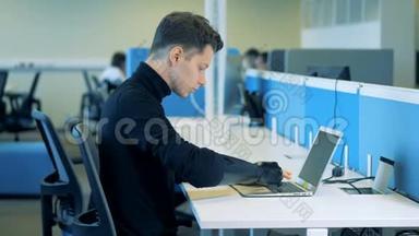 一个人造<strong>臂</strong>坐在键盘上打字的年轻人。 机器人<strong>机械臂</strong>概念。