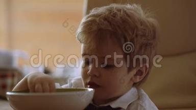 孩子看<strong>动画</strong>片。 <strong>小孩</strong>子在喝粥。 有趣的男孩吃牛奶粥