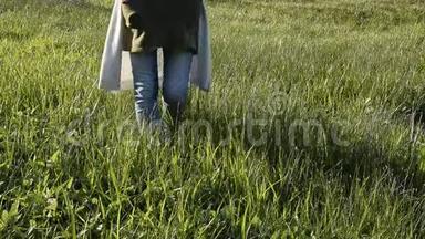 女人在<strong>清新</strong>的绿草中行走。 放松时间