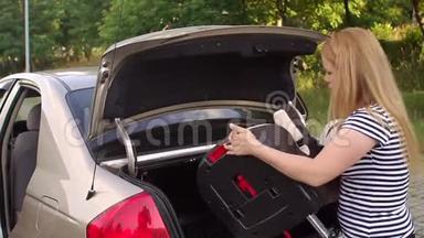 一个女人放在儿童汽车座椅的后备箱里。