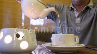 在餐厅里，人们端着茶壶，端着热茶在桌上