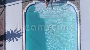 丰富的生活，苗条的女孩泳衣游泳在蓝色游泳池在暑假