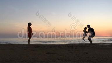 日落时，小女孩沿着海滩在父母之间奔跑。
