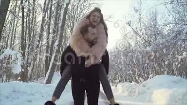 美丽的白人年轻夫妇在<strong>冬季</strong>公园<strong>约会</strong>。 他肩上扛着一个女孩