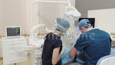 两<strong>名医</strong>生和病人坐在牙科诊所的椅子上